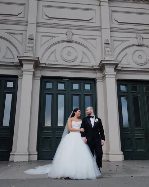 Newlyweds together outside an elegant building with deep green doors