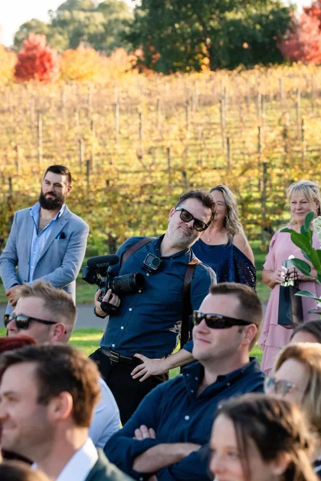 Gareth filming among the guests at a vineyard ceremony